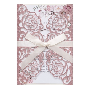 Detail of rose hollow laser-cut wedding invitation with pink glitter and satin ribbon