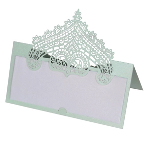 Detailed laser-cut crown pattern on a pale green tent-style wedding place card