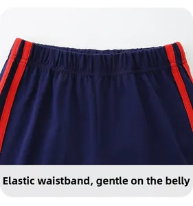 Detail der dunkelblauen Kinder-Baumwollshorts mit Gummibund und roten Seitenstreifen