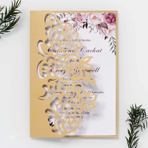 Detail of laser-cut hollow rose wedding invitation with golden sleeve and floral inner page