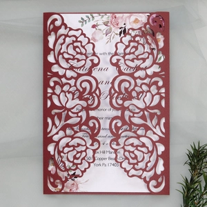 Detail of laser-cut burgundy rose wedding invitation with elegant watercolor floral insert