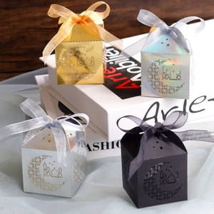 Detail of laser-cut moon candy boxes in gold and silver with elegant ribbon bows