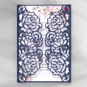 Macro view of laser-cut navy blue wedding invitation with glitter floral hollow design