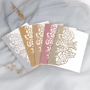 Macro detail of laser-cut glitter wedding invitations in elegant floral rose patterns
