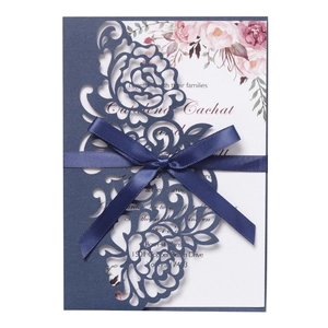 Navy laser-cut wedding invitation with silk bow and watercolor floral inner card