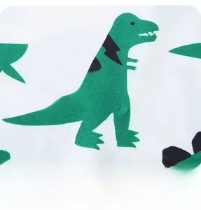 Détail du tissu en coton doux avec des imprimés de dinosaures verts mignons pour enfants