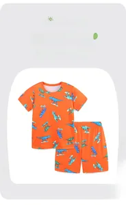Detail showing soft cotton fabric with vibrant dinosaur skating prints on orange kids set