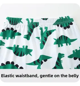 Détail de la taille élastique du pantalon enfant blanc avec motifs de dinosaures verts
