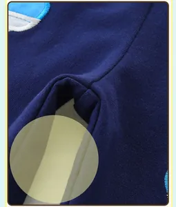 Gros plan détaillé montrant les coutures et les broderies sur un vêtement en tricot bleu