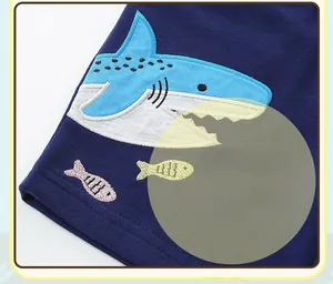 Gros plan détaillé du tissu en maille bleu marine avec broderie de requin pour enfant