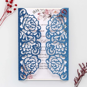 Close-up of laser-cut rose patterns on glitter navy blue wedding invitation cards