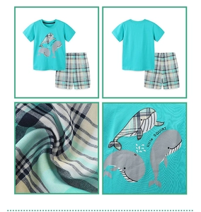 Detail view of cotton boy's pajama set featuring blue whale print and plaid shorts texture