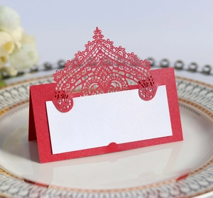 Detail of red laser-cut lace place card with white insert on a ceramic dinner plate