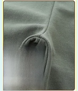 Gros plan du tissu en coton tricoté vert olive montrant les détails de couture en croix