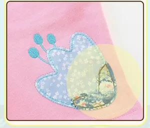Detailed embroidery of a floral butterfly patch on pink cotton fabric for kids' clothing