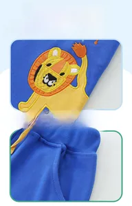 Close-up of royal blue children's shorts featuring lion embroidery and yellow drawstring