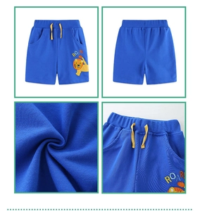 Detail view of boys' royal blue shorts with lion embroidery and yellow drawstring