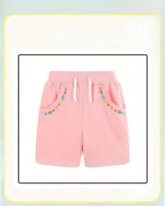 Detail of pink cotton girl shorts featuring floral embroidery and white drawstring waist