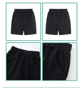 Detail view of boys black knit cotton shorts showing elastic waist with drawstring and pockets