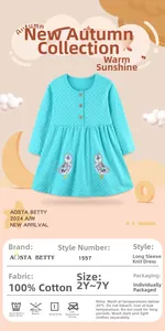 Détail des hiboux brodés sur une robe en maille de coton turquoise à pois blancs