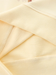 Close-up of cream knit sweatshirt fabric with premium rib-knit cuffs and French Terry texture