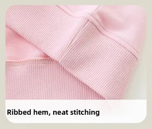 Vue détaillée de l'ourlet côtelé et des coutures soignées sur le sweat en maille rose