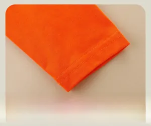 Zoom sur le poignet d'un t-shirt orange montrant les détails de couture double