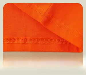 Détail de l'ourlet à double surpiqûre sur un t-shirt orange à manches longues enfant