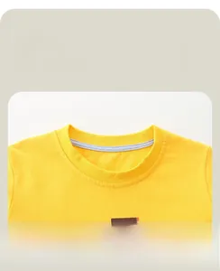 Détail du col rond renforcé et de l'imprimé tracteur sur le T-shirt en coton jaune pour garçon