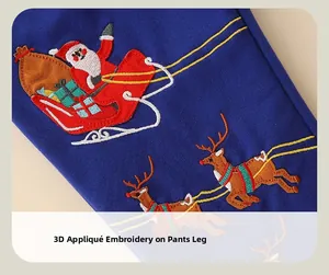 Detailed close-up of Santa Claus and reindeer embroidery on dark blue trousers