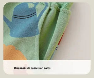 Close-up of boys' light green cotton pants featuring side pockets and blue cartoon prints