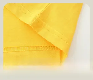 Gros plan de l'ourlet du T-shirt jaune en coton avec couture plate à double aiguille