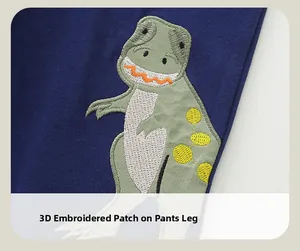 Détail de la broderie dinosaure 3D sur le pantalon en coton bleu marine pour garçon