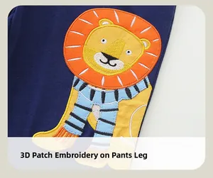 Détail de l'applique lion et broderie sur un pantalon en coton bleu marine pour enfant
