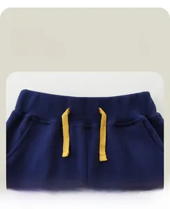 Detail of kids navy sports trousers featuring elastic waistband and bright yellow drawstring