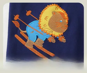 Detailed close-up of cartoon skiing lion embroidery on navy blue cotton sports pants