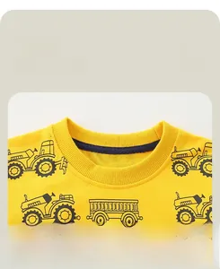 Close-up of durable ribbed neckline and tractor print on yellow cotton sweatshirt