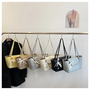 Detailed view of six colorful leather tote bags featuring lace bows and pearl charms