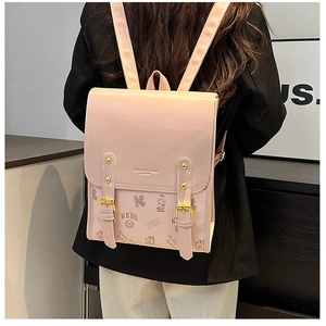 Détail du sac à dos en cuir rose avec texture litchi et finitions en métal doré