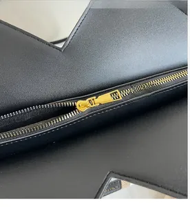 Macro view of smooth gold metal zipper and premium black leather texture on tote bag