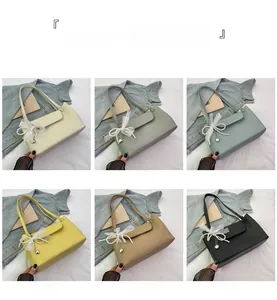 Close-up of litchi pattern leather handbags with lace bows and heart pendants in six colors
