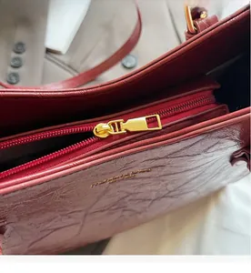 Close-up of golden zipper and oily wax leather texture on a vintage tote bag