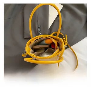 Top view of yellow mini bucket bag interior showing makeup storage and zipper detail