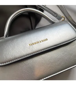 Detail of silver metallic handbag featuring pleated texture and gold logo branding