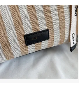Detail of woven striped fabric texture with leather label and logo canvas strap