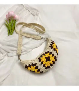 Detail of bohemian crochet sunflower bag with half-moon shape and woven shoulder strap