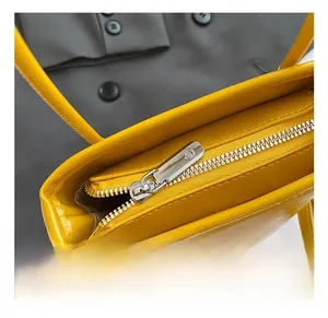 Close-up of litchi texture yellow leather bag featuring a premium silver metal zipper
