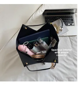 Spacious interior of black pebble leather tote bag showing items for daily organization
