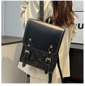 Vue macro du sac à dos en cuir noir avec boucles dorées et imprimé vintage
