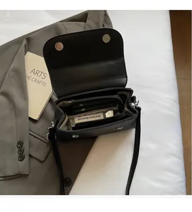 Detail view of black faux leather shoulder bag interior with zipper compartment